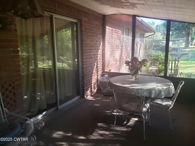 a dining room with glass top table and chairs