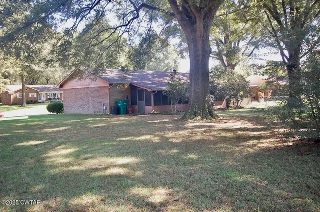 a front view of a house with a yard and trees