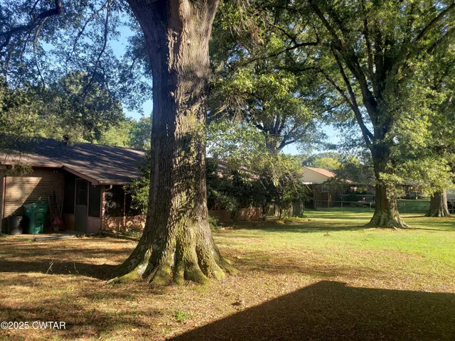 a view of swimming pool with a garden and trees