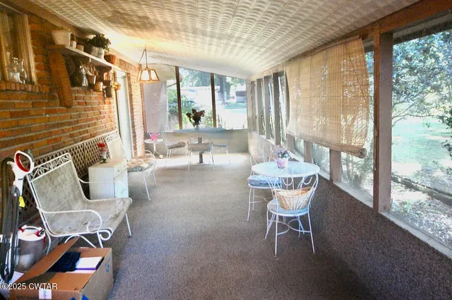 a dining room with furniture and a large window