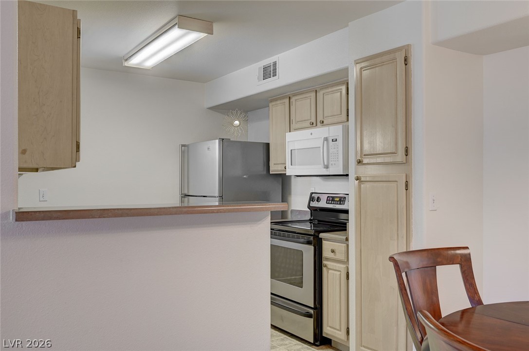 555 East Silverado Ranch Boulevard, Unit 2124 Las Vegas, NV 89183 - Photo 22 of 47 A well-appointed culinary space featuring sleek stainless steel appliances and practical cabinetry.