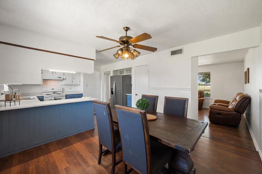 2038 Forreston Road Waxahachie, TX 75165 - Photo 16 of 39 Dining area featuring dark wood-style flooring, a ceiling fan, and a textured ceiling