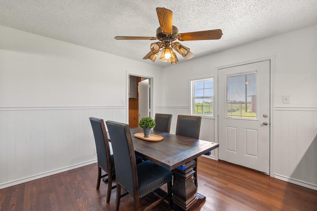 2038 Forreston Road Waxahachie, TX 75165 - Photo 18 of 39 Dining space featuring wood finished floors, wainscoting, a textured ceiling, and ceiling fan