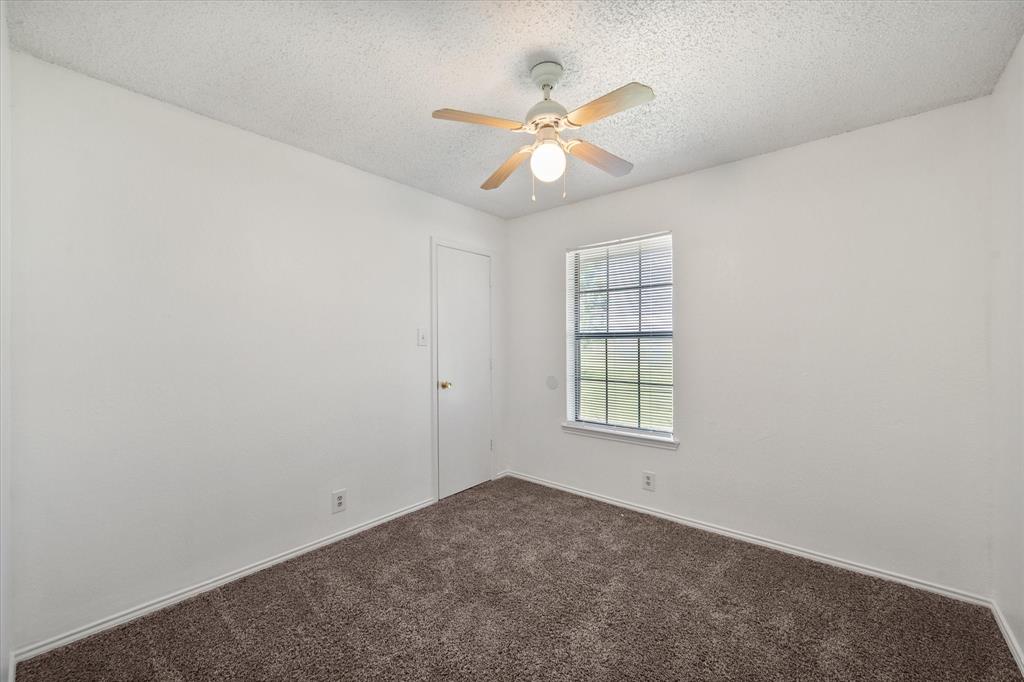 2038 Forreston Road Waxahachie, TX 75165 - Photo 19 of 39 Unfurnished room with dark colored carpet, a ceiling fan, and a textured ceiling