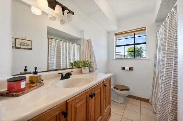 a bathroom with a sink a toilet and a window