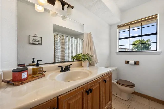 an empty room with windows and chandelier fan