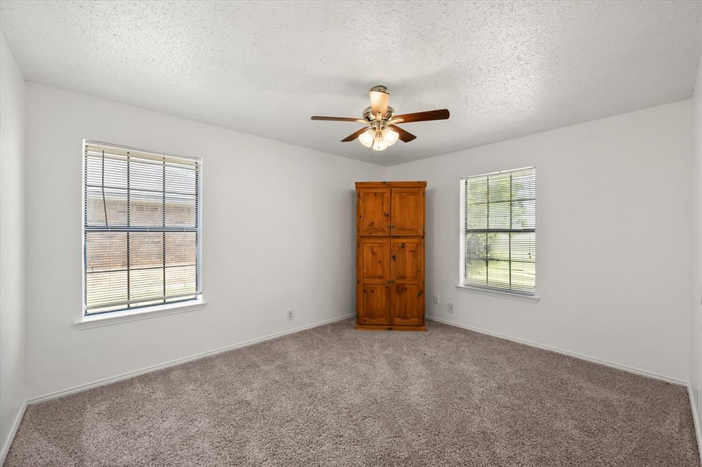 2038 Forreston Road Waxahachie, TX 75165 - Photo 22 of 39 Unfurnished room featuring healthy amount of natural light, a ceiling fan, light colored carpet, and a textured ceiling
