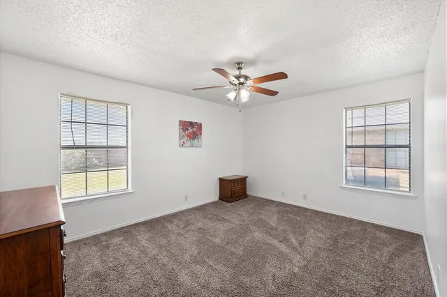 an empty room with chandelier fan