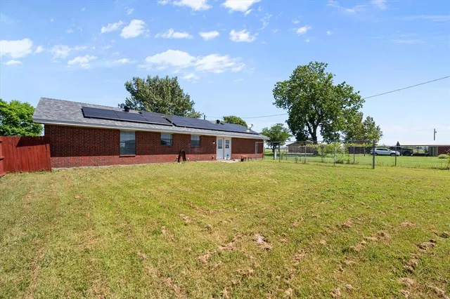 a view of backyard of house with green space