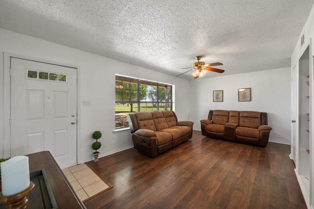 2038 Forreston Road Waxahachie, TX 75165 - Photo 5 of 39 Living area with dark wood-type flooring, a textured ceiling, and a ceiling fan