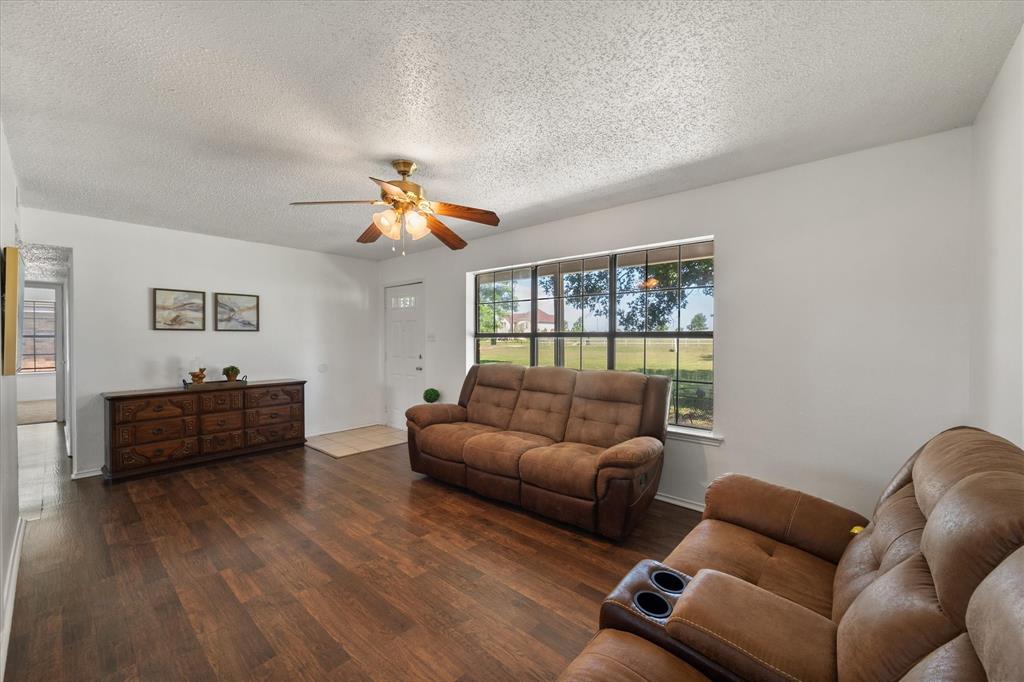 2038 Forreston Road Waxahachie, TX 75165 - Photo 8 of 39 Living room featuring a textured ceiling, ceiling fan, and dark wood-style flooring