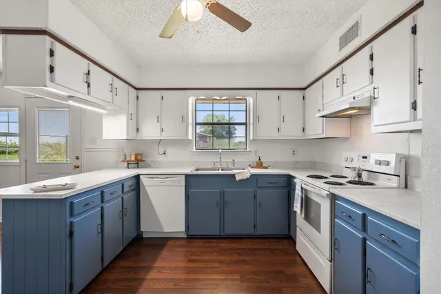 a kitchen with cabinets wooden floor and a sink
