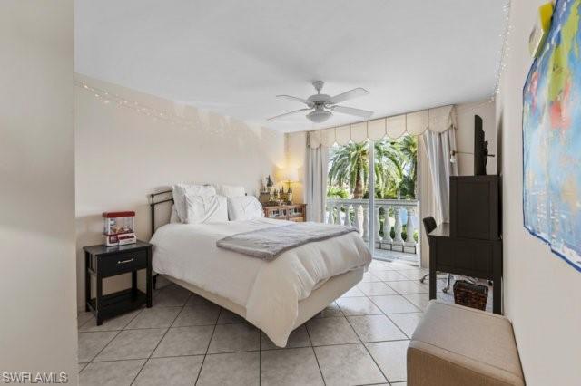 6573 Marissa Loop, Unit 105 Naples, FL 34108 - Photo 19 of 42 a bedroom with a bed and a large window