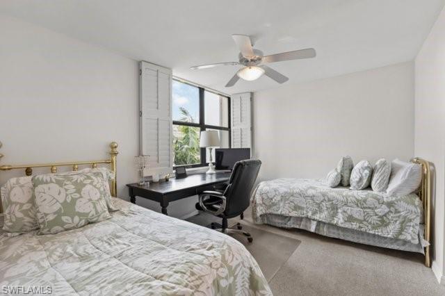 6573 Marissa Loop, Unit 105 Naples, FL 34108 - Photo 20 of 42 a bedroom with a bed and a chandelier