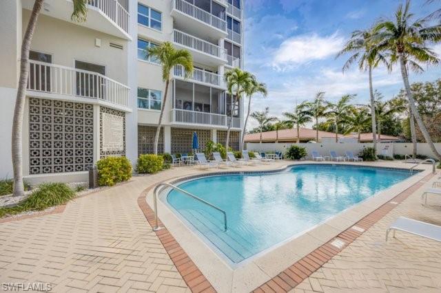 6573 Marissa Loop, Unit 105 Naples, FL 34108 - Photo 32 of 42 a view of a swimming pool with a lounge chairs