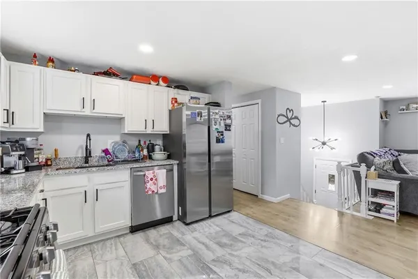 a kitchen with stainless steel appliances a refrigerator sink and cabinets