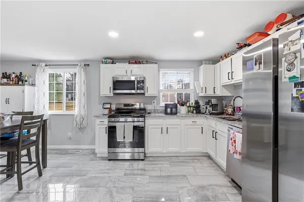 a kitchen with stainless steel appliances granite countertop a refrigerator sink and stove
