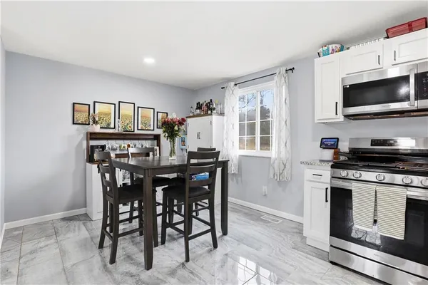 a kitchen with a dining table and stainless steel appliances