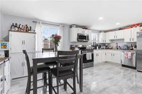 a kitchen with a table chairs microwave and cabinets