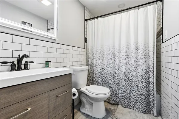 a bathroom with a sink a toilet and shower curtain