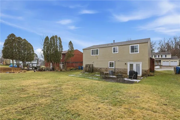 a backyard of a house with barbeque oven and outdoor seating