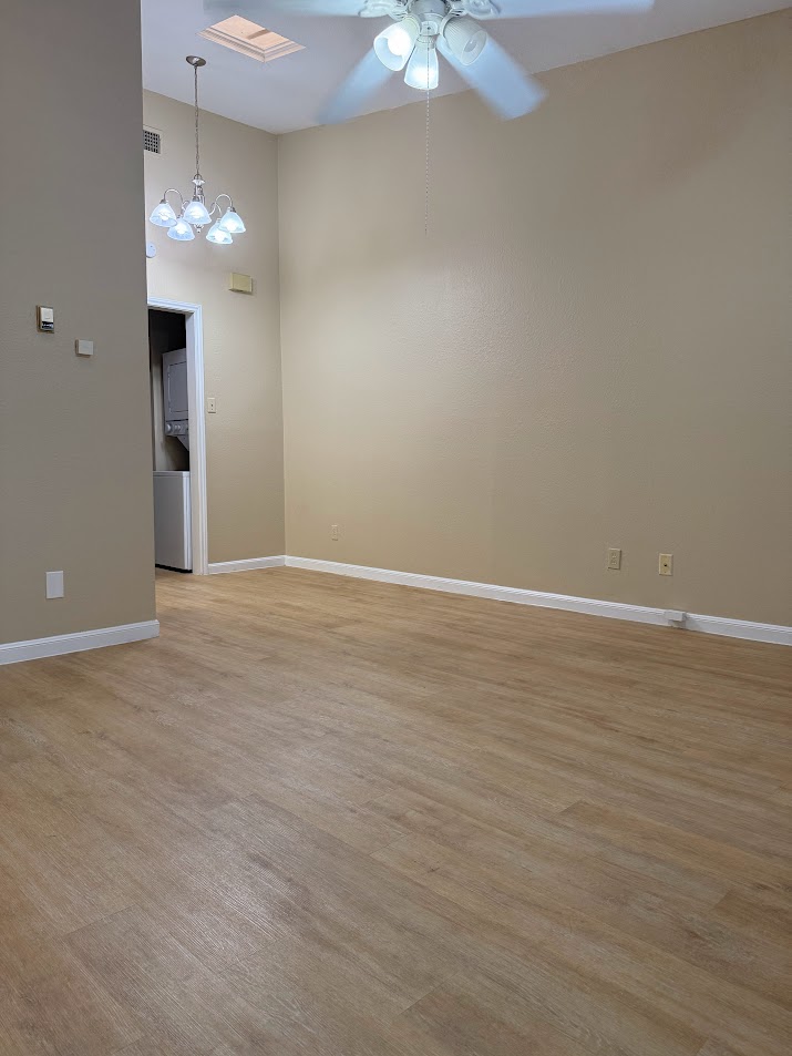2529 Rio Grande Street, Unit 96 Austin, TX 78705 - Photo 4 of 11 Unfurnished room featuring ceiling fan, light wood finished floors, baseboards, and a towering ceiling