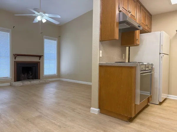 a view of a kitchen with refrigerator and a fireplace