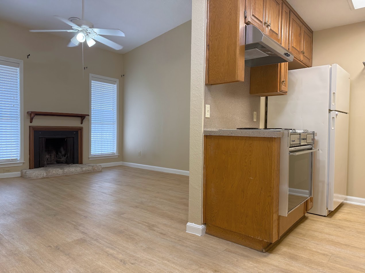 2529 Rio Grande Street, Unit 96 Austin, TX 78705 - Photo 5 of 11 Kitchen with light wood-type flooring, under cabinet range hood, range with gas cooktop, and brown cabinetry