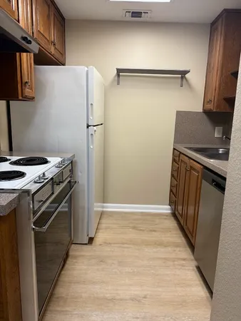 a kitchen with a stove top oven and refrigerator