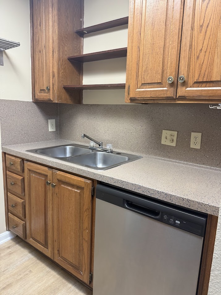 2529 Rio Grande Street, Unit 96 Austin, TX 78705 - Photo 7 of 11 Kitchen featuring stainless steel dishwasher, a sink, open shelves, and decorative backsplash