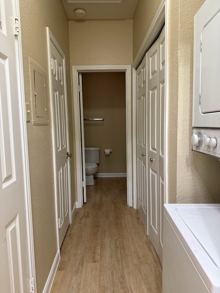 2529 Rio Grande Street, Unit 96 Austin, TX 78705 - Photo 8 of 11 Hallway featuring light wood-style floors, a textured wall, and electric panel