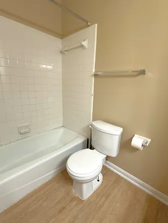 a white toilet and tub sitting next to a bathroom sink