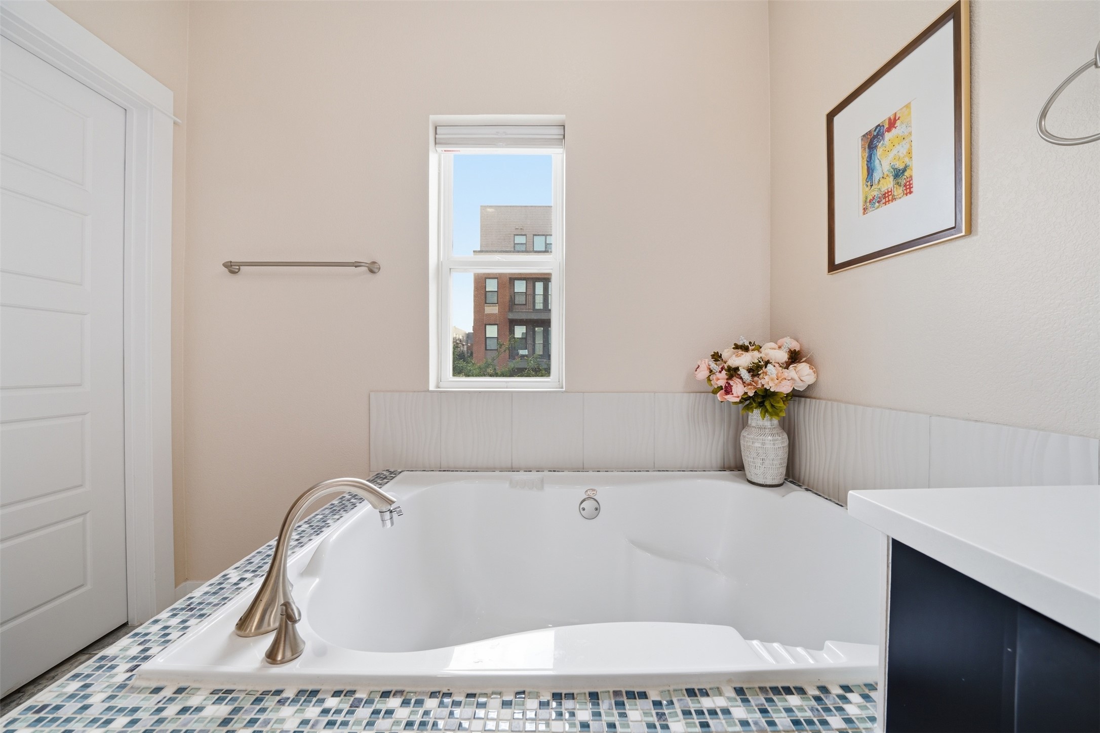 3901 Vaughan Street Austin, TX 78723 - Photo 24 of 37 Built-in tub with brushed nickel fixtures, surrounded by a mosaic tile deck and white subway tile wainscoting