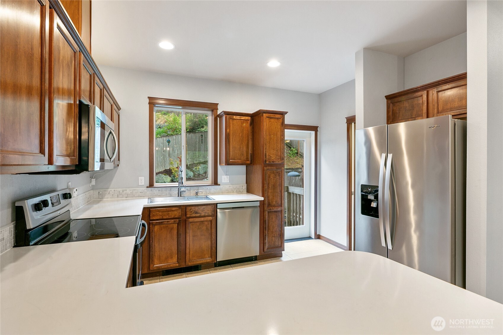 2923 Belmonte Lane Everett, WA 98201 - Photo 13 of 33 a large kitchen with stainless steel appliances granite countertop a refrigerator a sink dishwasher a stove and a refrigerator with wooden floor