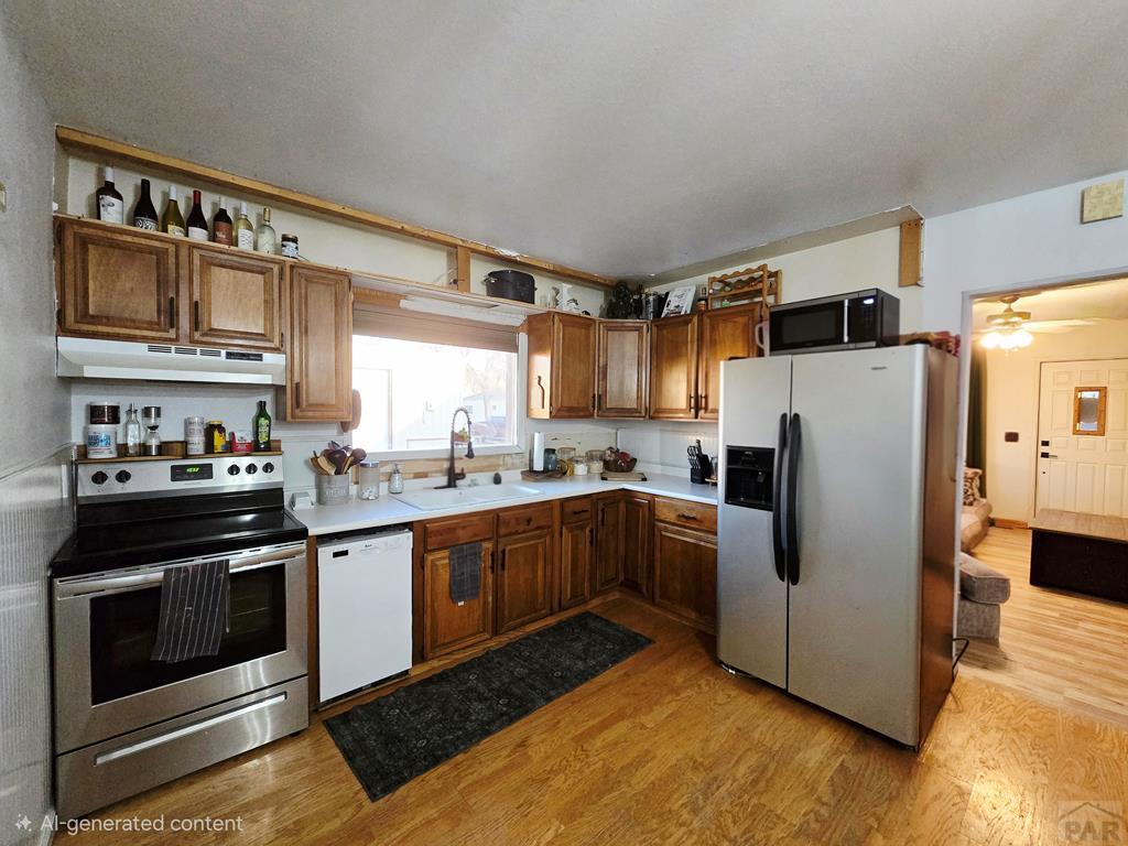 205 3rd Street Swink, CO 81077 - Photo 4 of 26 a kitchen with stainless steel appliances granite countertop a refrigerator a stove a sink and a microwave