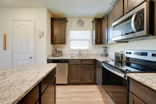 a kitchen with stainless steel appliances granite countertop a sink stove and cabinets
