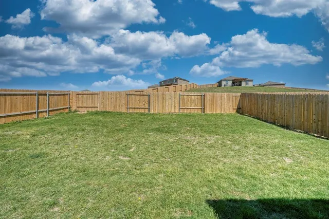 a view of a yard with wooden fence