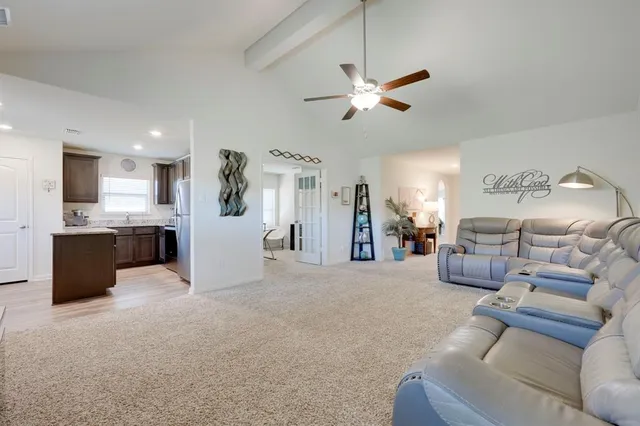 a living room with furniture and kitchen