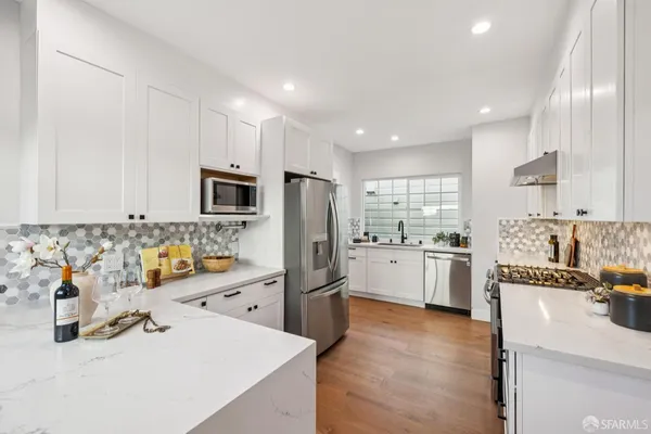 a kitchen with white cabinets and stainless steel appliances