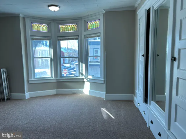 an empty room with windows wooden floor and windows