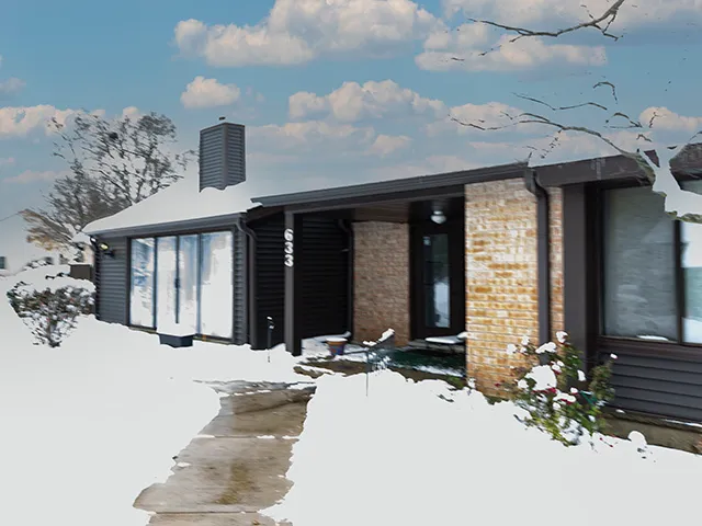 a front view of a house with a yard covered in snow