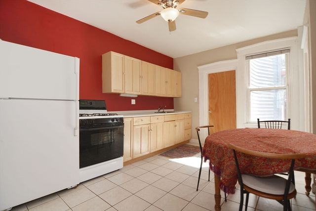 a kitchen with stainless steel appliances a stove a sink and white cabinets