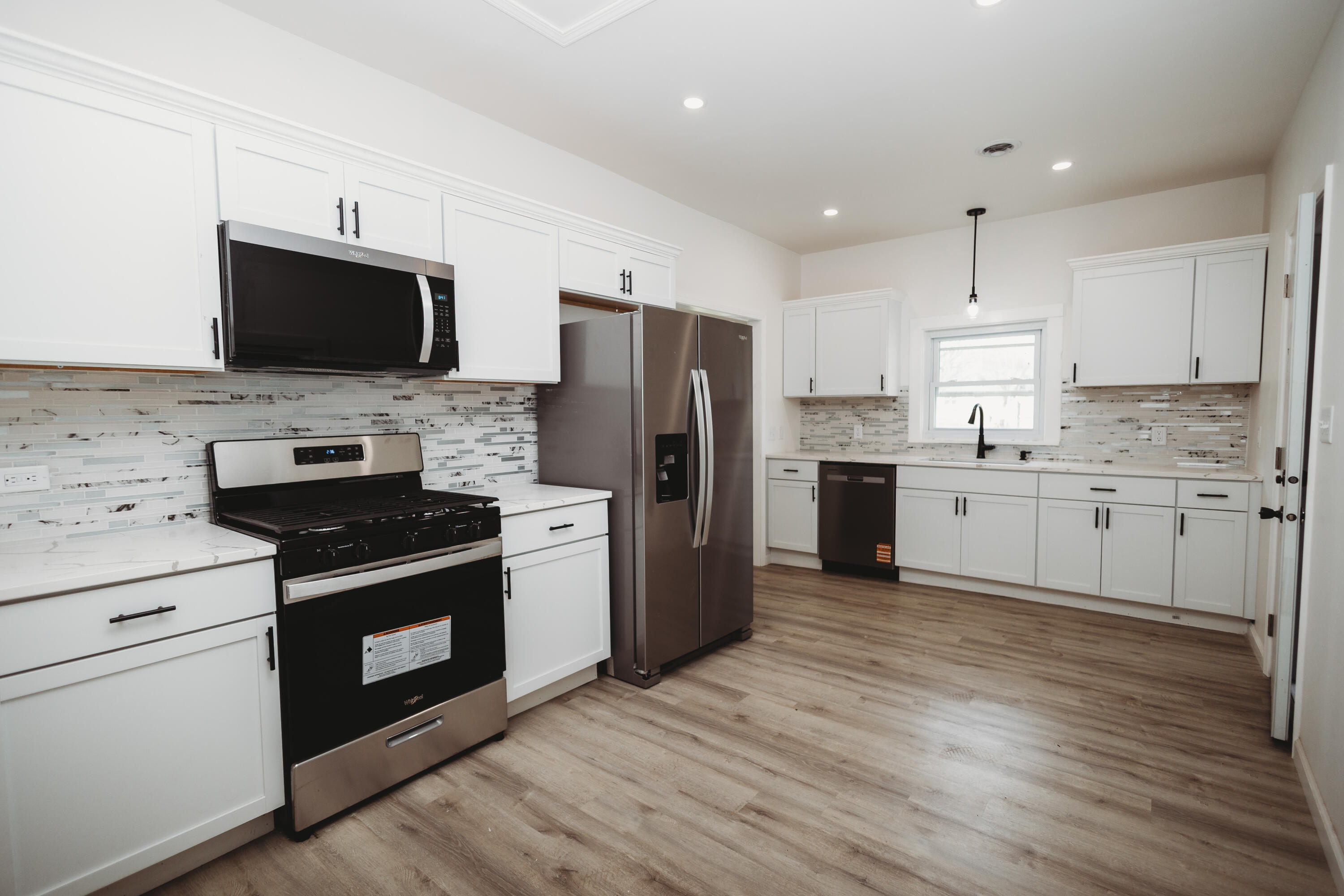 4812 East Bootjack Road Rolling Prairie, IN 46371 - Photo 6 of 13 a kitchen with stainless steel appliances granite countertop a stove top oven a refrigerator a sink and a microwave