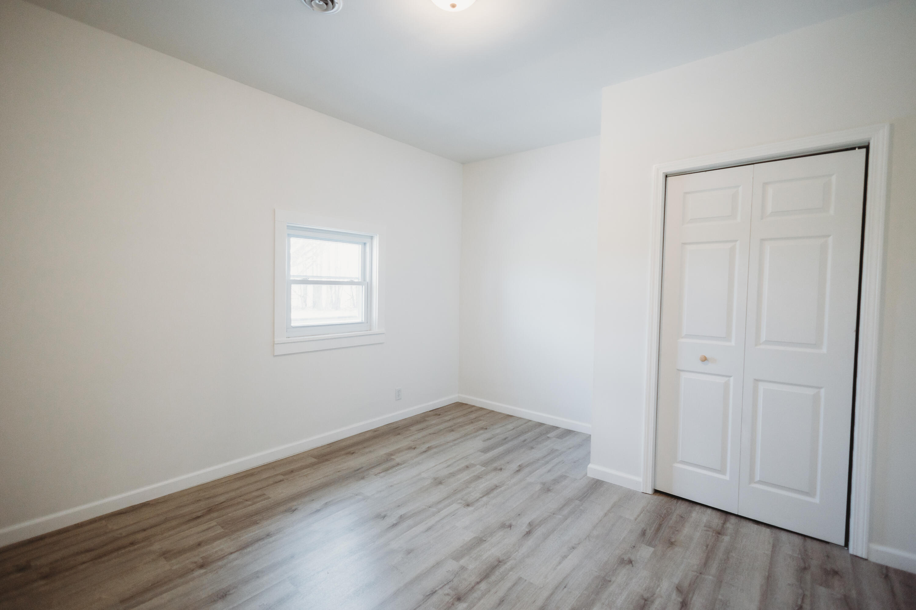 4812 East Bootjack Road Rolling Prairie, IN 46371 - Photo 10 of 13 an empty room with wooden floor and windows