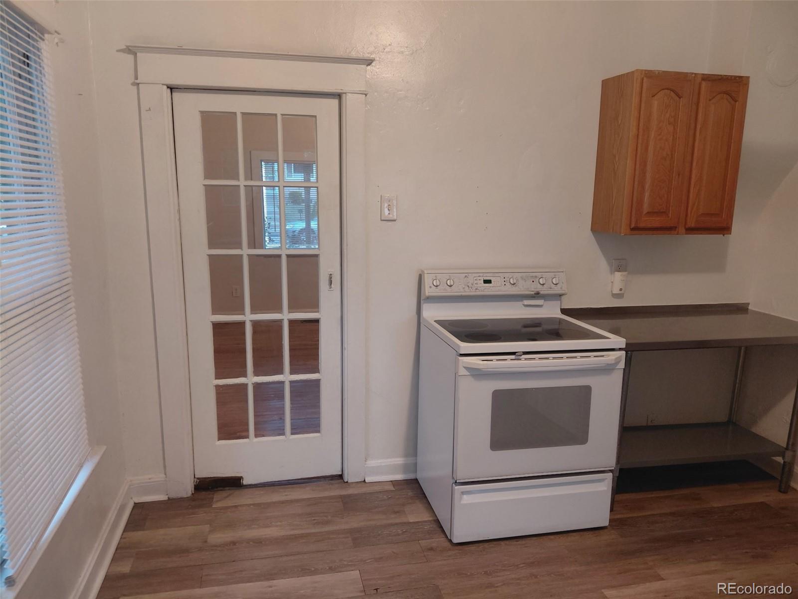 1917 South Fox Street Denver, CO 80223 - Photo 3 of 10 a kitchen with a stove cabinets and wooden floor