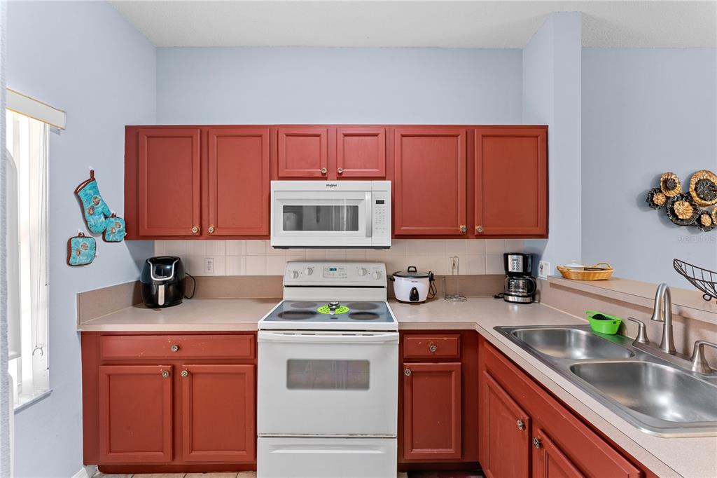 1017 Park Ridge Circle Kissimmee, FL 34746 - Photo 11 of 52 a kitchen with stainless steel appliances granite countertop a sink dishwasher stove and cabinets
