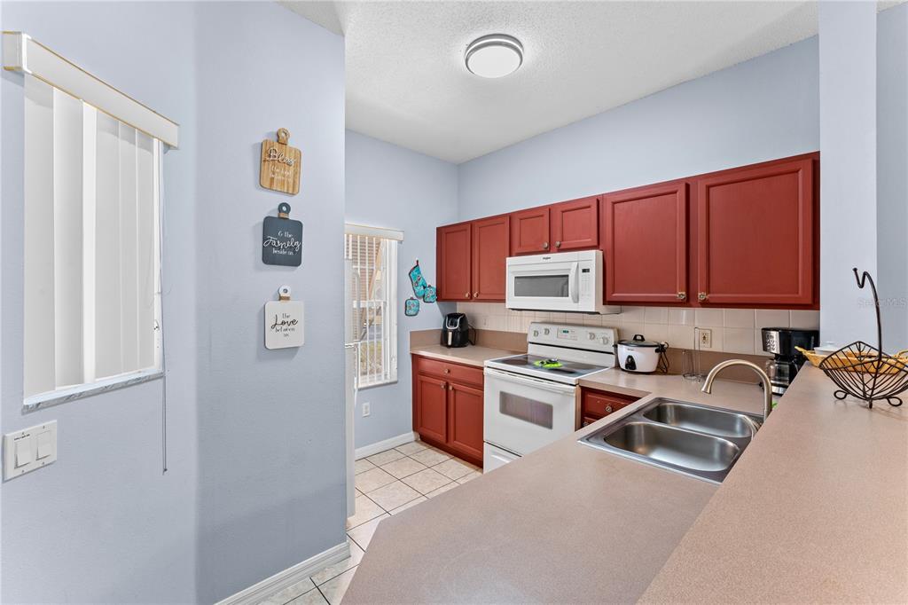 1017 Park Ridge Circle Kissimmee, FL 34746 - Photo 12 of 52 a kitchen with stainless steel appliances granite countertop a refrigerator sink and stove