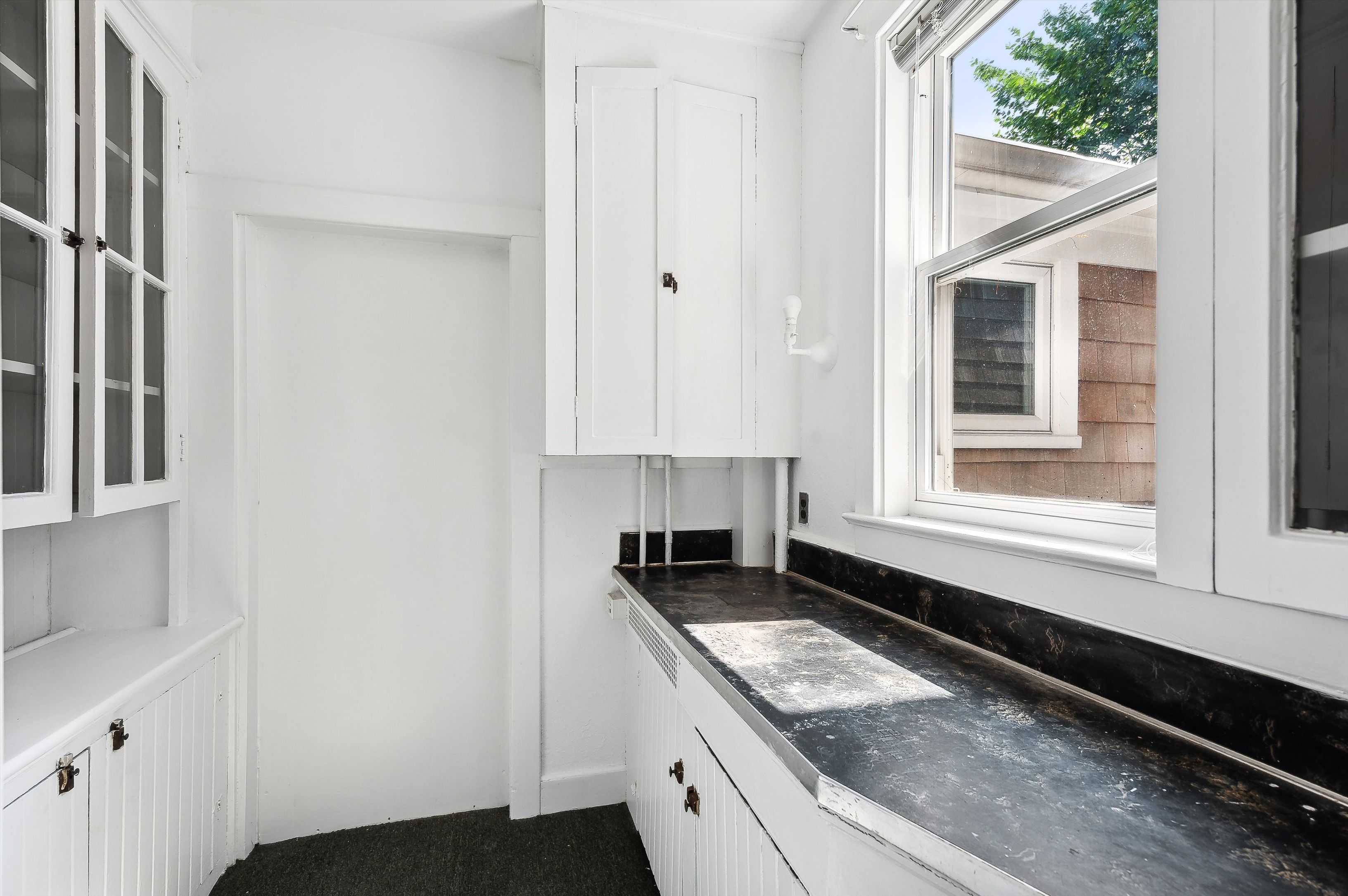 10 Pantigo Road East Hampton, NY 11937 - Photo 14 of 28 a kitchen with granite countertop white cabinets and window