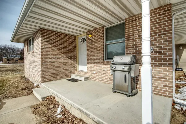 a view of a backyard with plants and barbeque grill