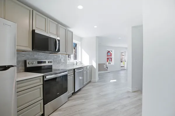 a kitchen with stainless steel appliances granite countertop a stove top oven a sink and dishwasher